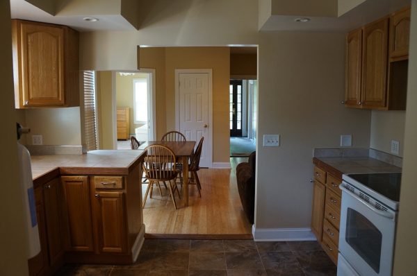 A kitchen with an archway into the dining room