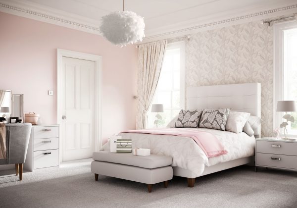 A modern bedroom with white and pink furnishings