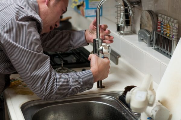 Close up of a plumber fixing a tap