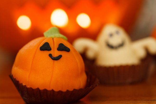 A pumpkin and ghost cupcake