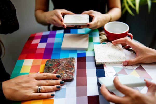 A group of people sitting at the table with different slabs of material