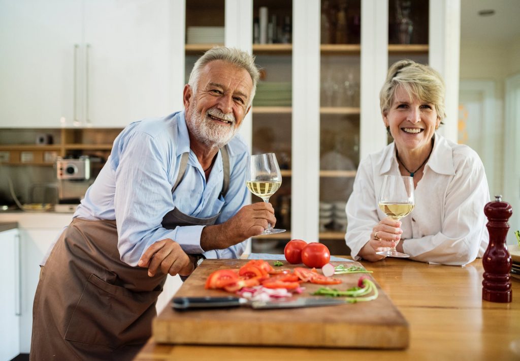 a couple holding wine glasses in a kitchen